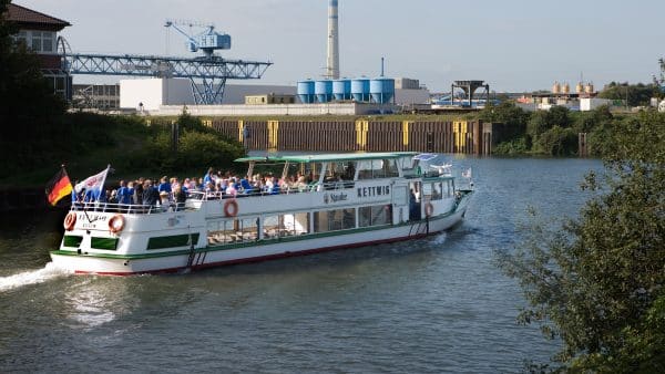 Das weiße Schiff "Kettwig" fährt mit Passagieren über einen Kanal.